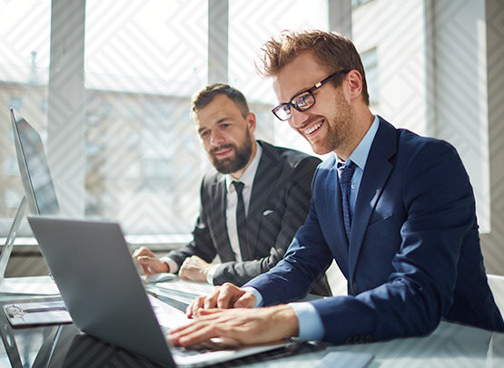 Two young professionals looking at a computer.